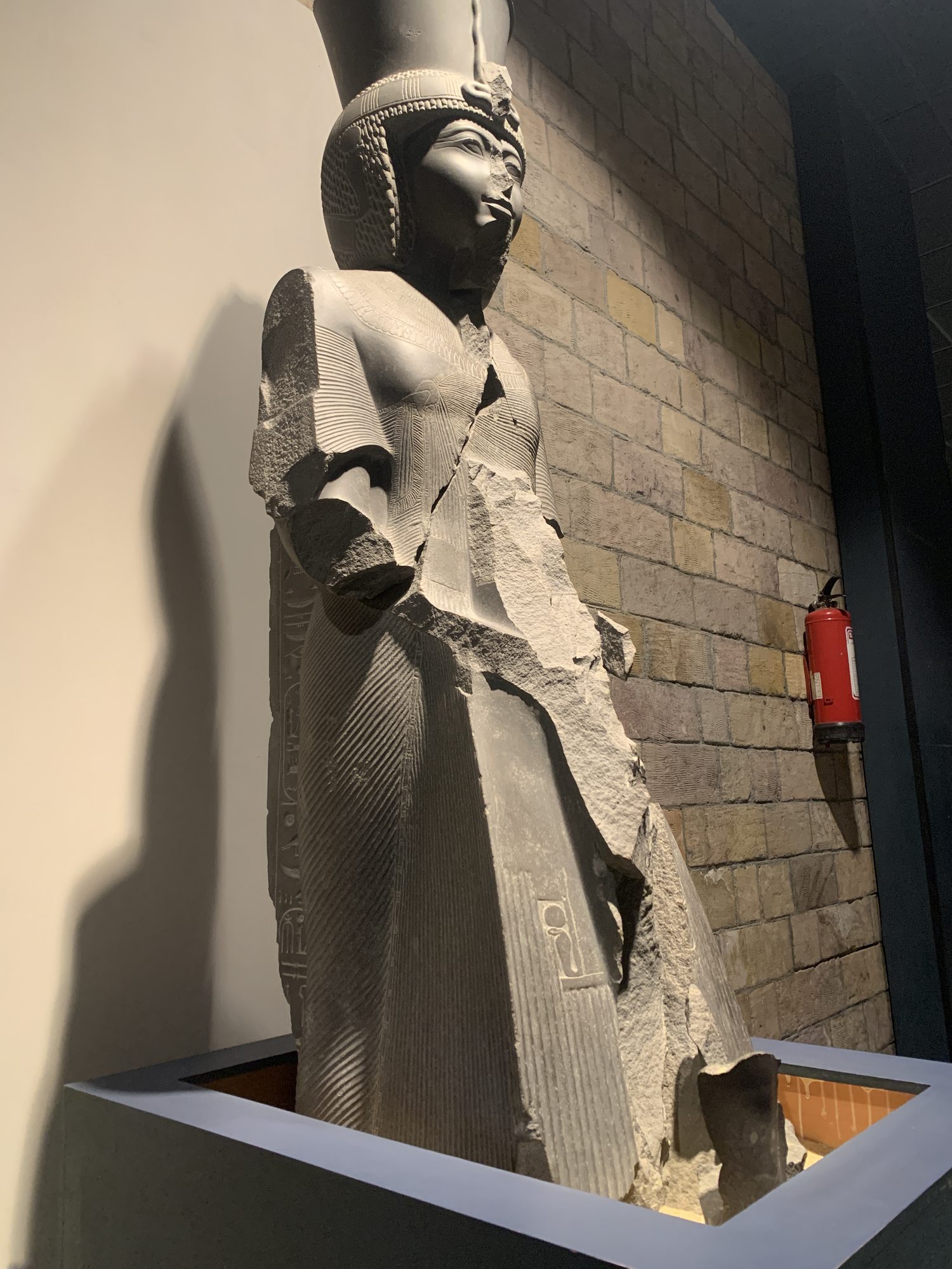 Statue of Ramses III displayed in Luxor Museum with base and back support visible